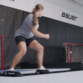 a girl sliding and lunging back and forth on a black slide platfor