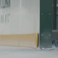 close up on a pair of white ice skates gliding out onto the ice