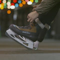 lacing up Bauer Whistler skates next to an outdoor ice rink in NYC