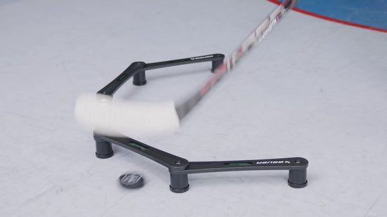 a hockey player stickhandling and passing a puck through the gates of an electronic stickhandling tool